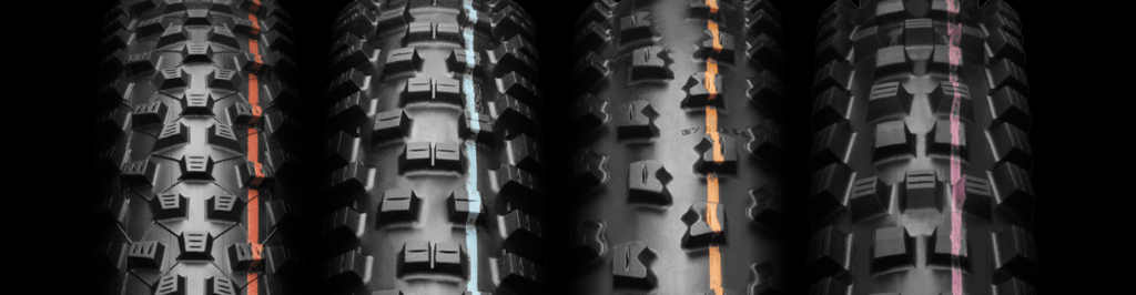 Close-up of Schwalbe mountain bike tires with various tread patterns and colored compound lines.